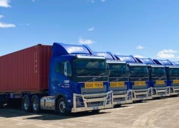 Visy Logistics Volvo prime movers carrying hay in containers.
